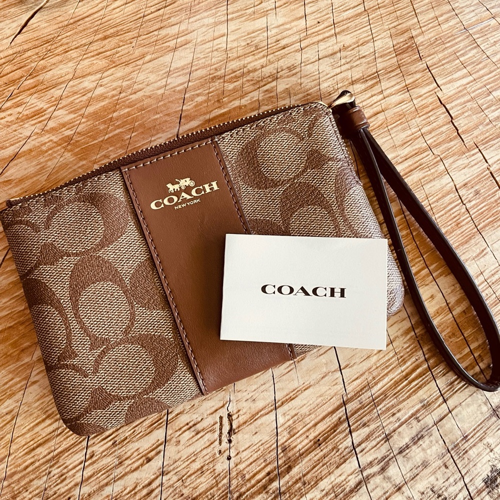 COACH Corner zip wristlet. Signature print with leather stripe.